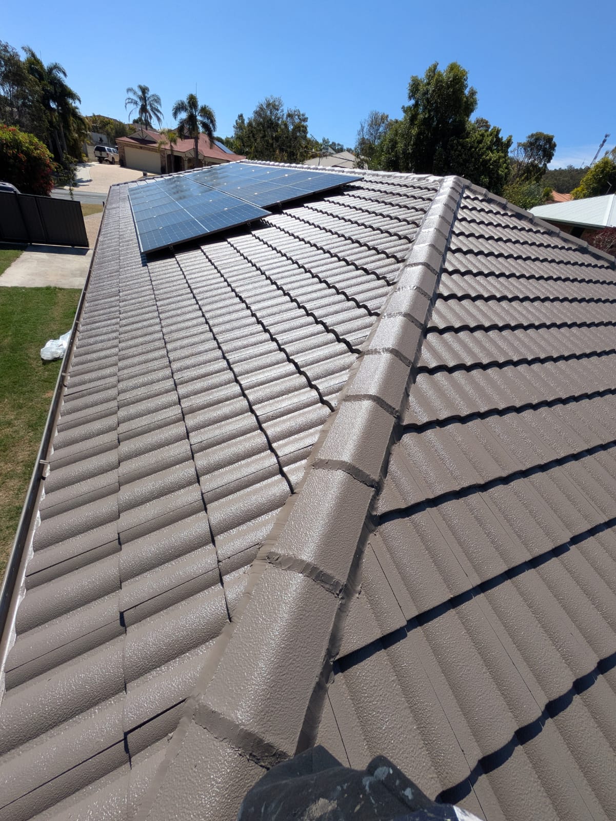 Freshly coated tile roof, sealed and protected around solar